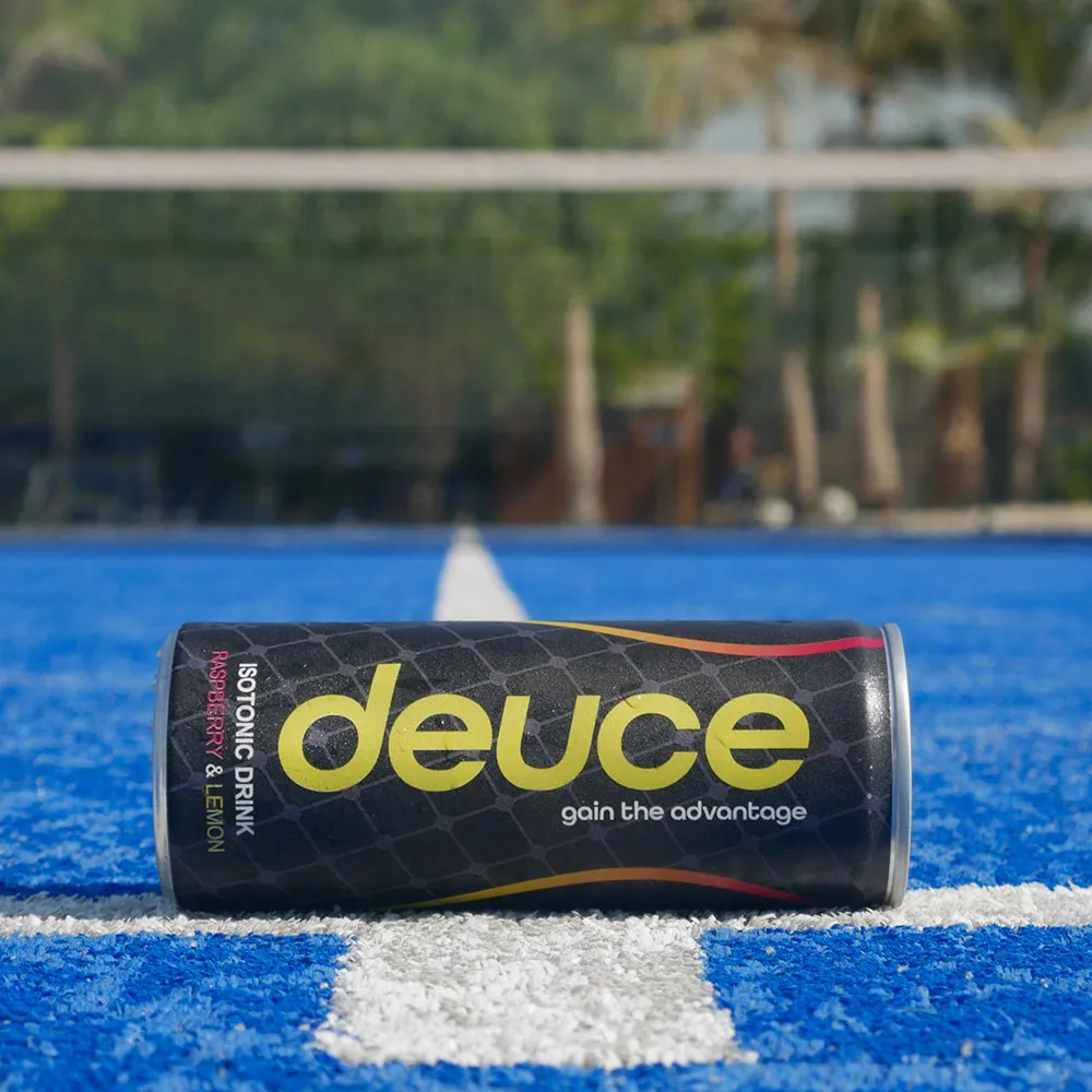 A can of deuce sitting on a blue tennis court.