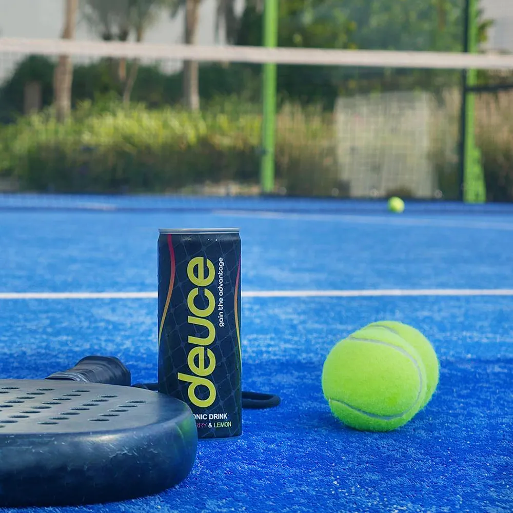 A tennis racket and a ball on a tennis court with a can of deuce.